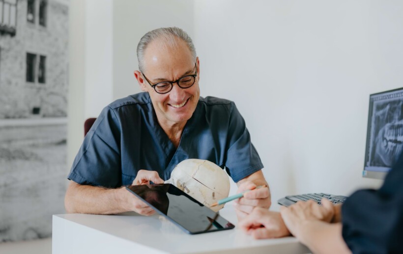 Prof. Schierle erl&auml;utert einem Patienten anschaulich an einem Kiefermodell und einem 3D-Scan die Entfernung seiner Weisheitsz&auml;hne